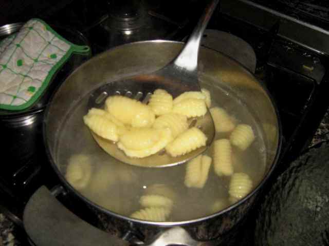 taking gnocchi from pot